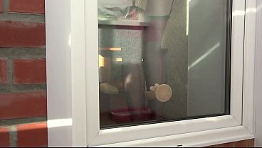 Image A neighbor watches through the window, as a MILF fucks herself with a dildo by the balcony door. Beautiful ass in doggy style.